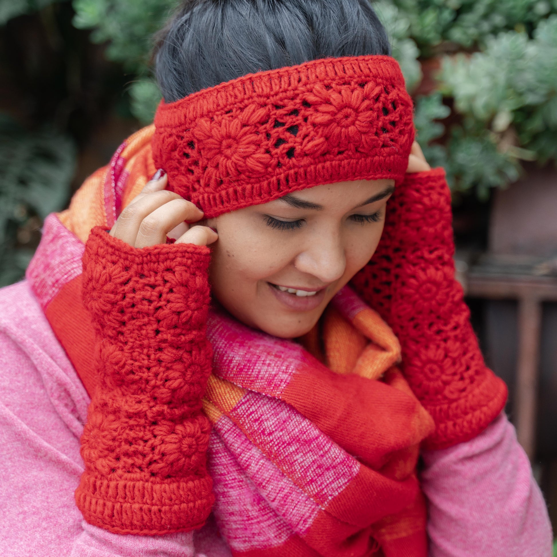 Detailfoto van vilten handwarmers granny square rood