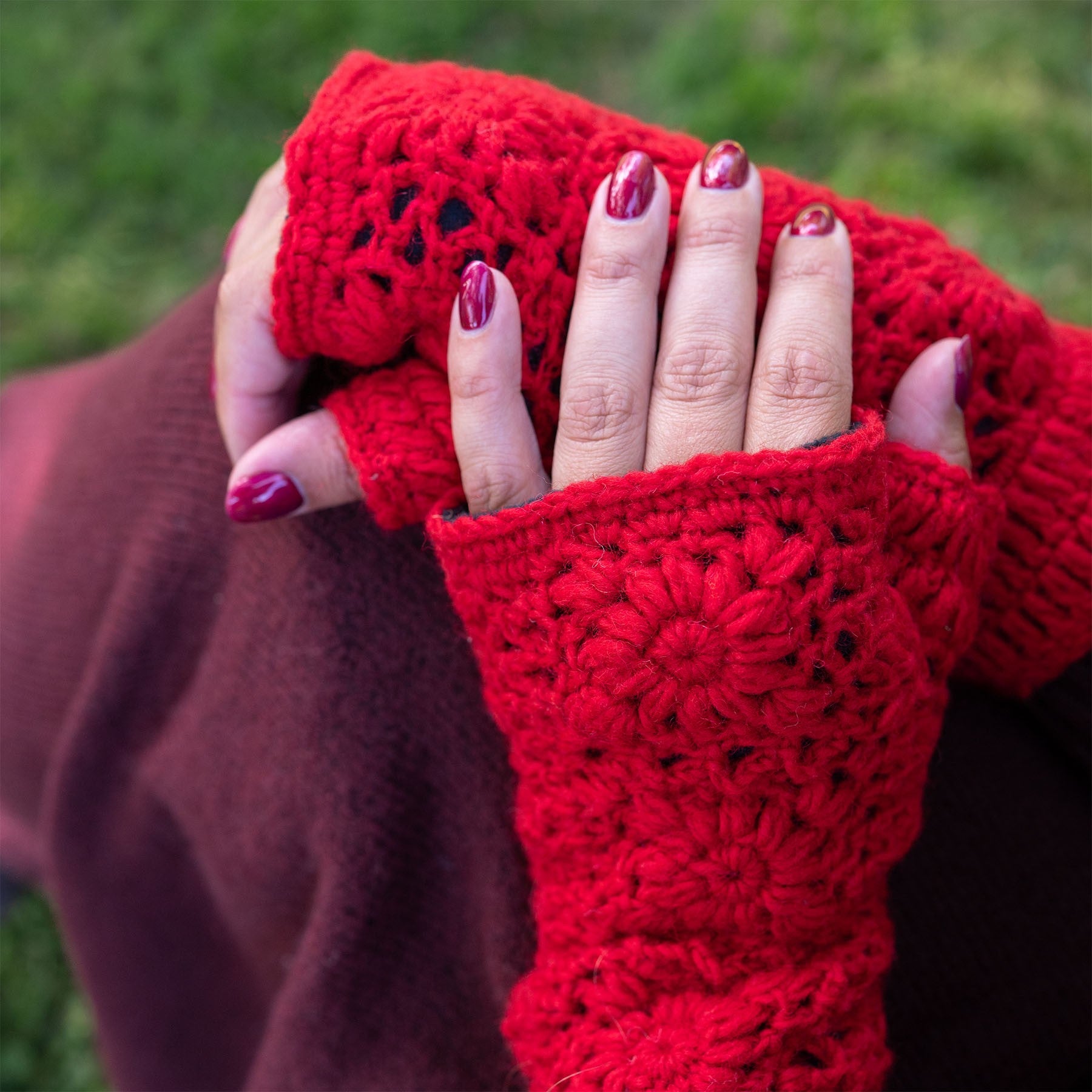 Detailfoto van vilten handwarmers granny square rood