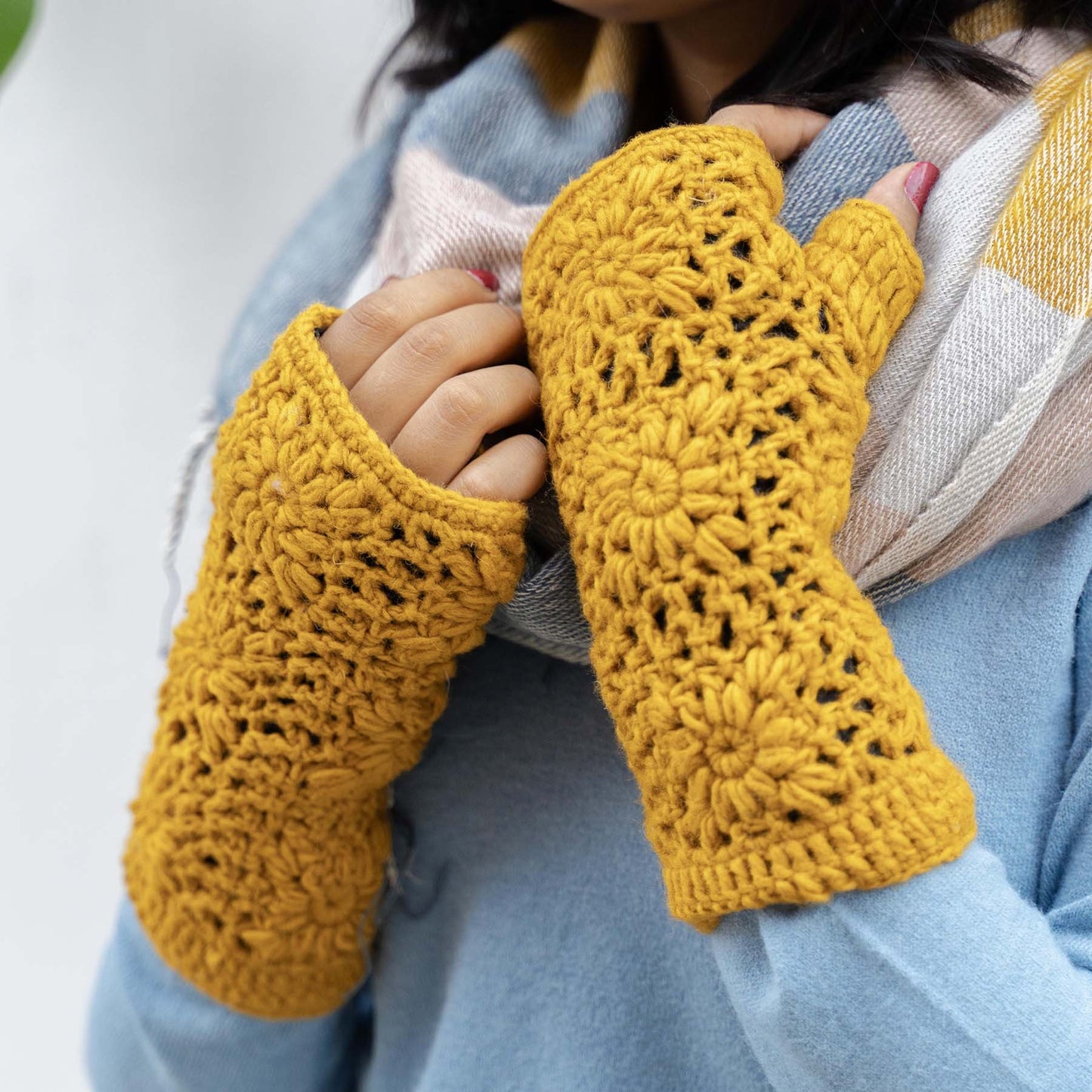 Detailfoto van vilten handwarmers granny square okergeel