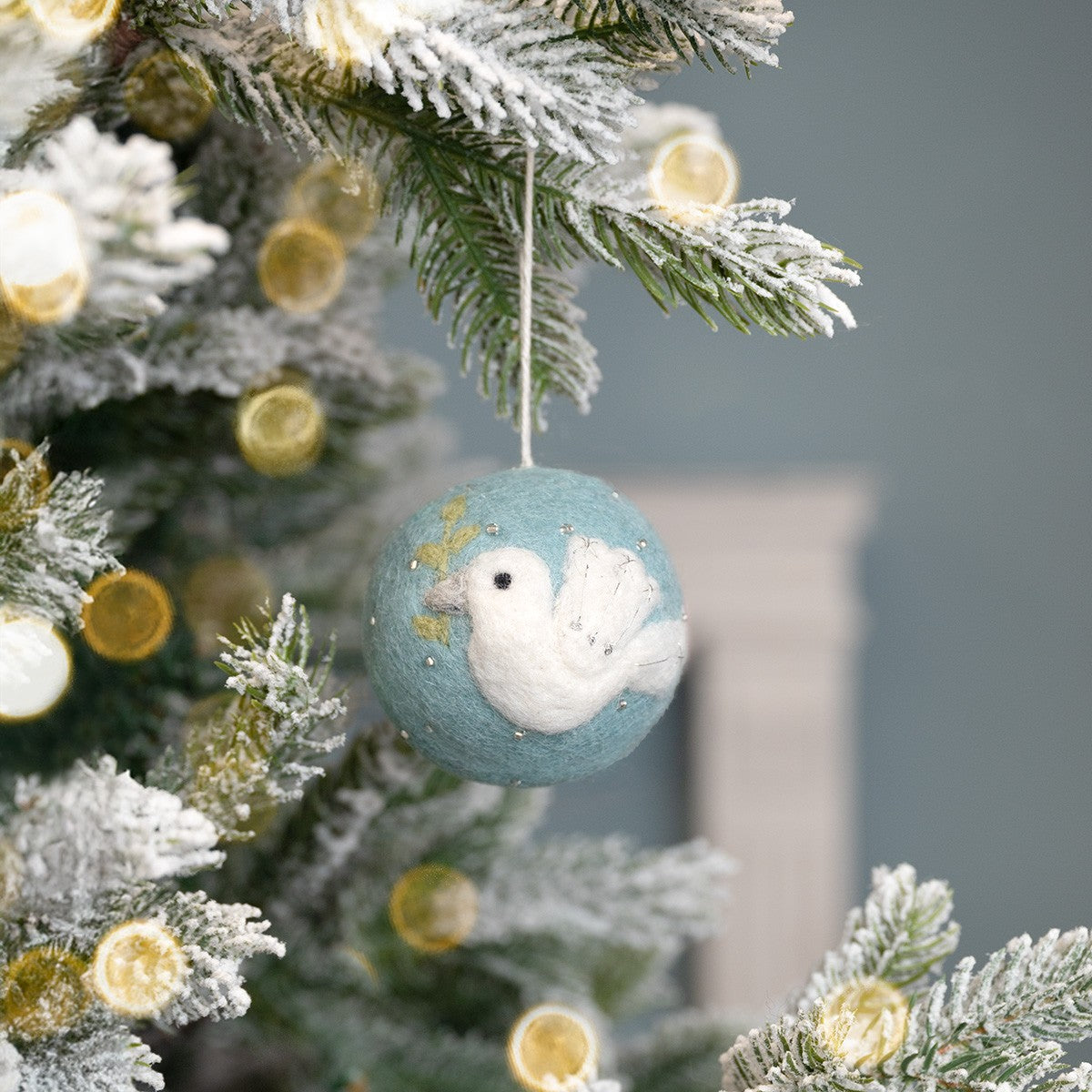 Detailfoto van kerstbal ijsblauw vredesduif van vilt
