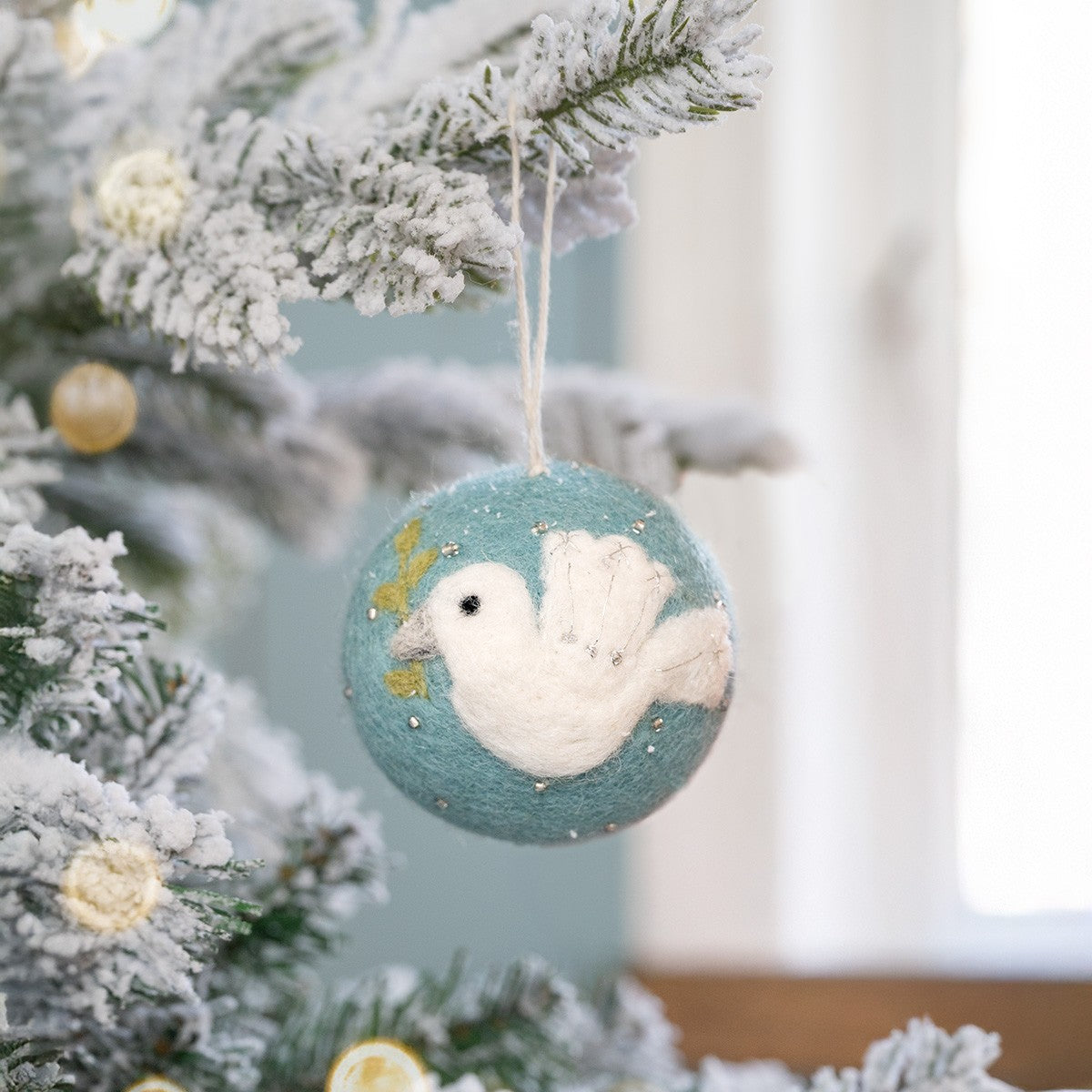 Detailfoto van kerstbal ijsblauw vredesduif van vilt