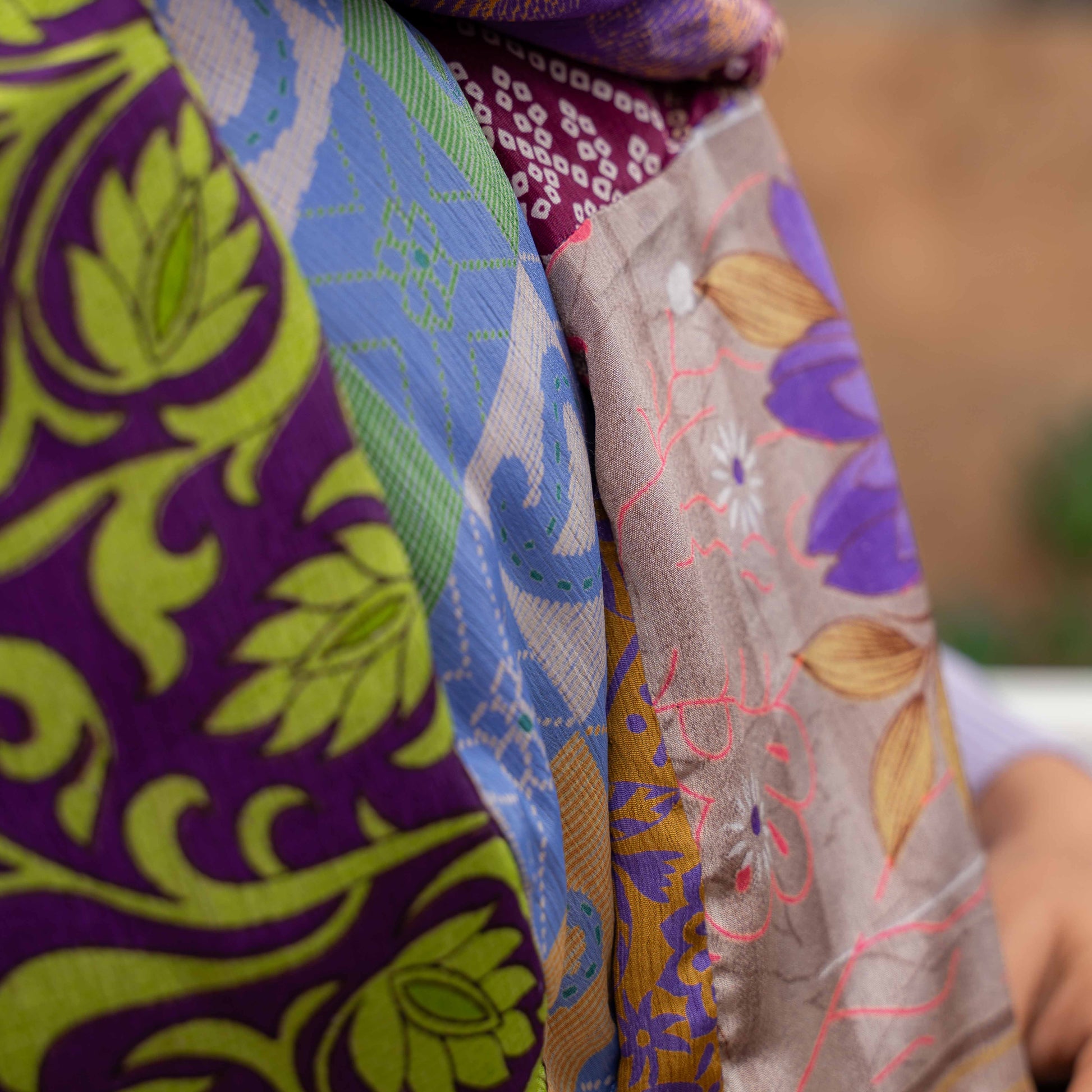 Detailfoto van vilten sarisjaal patchwork paarstinten
