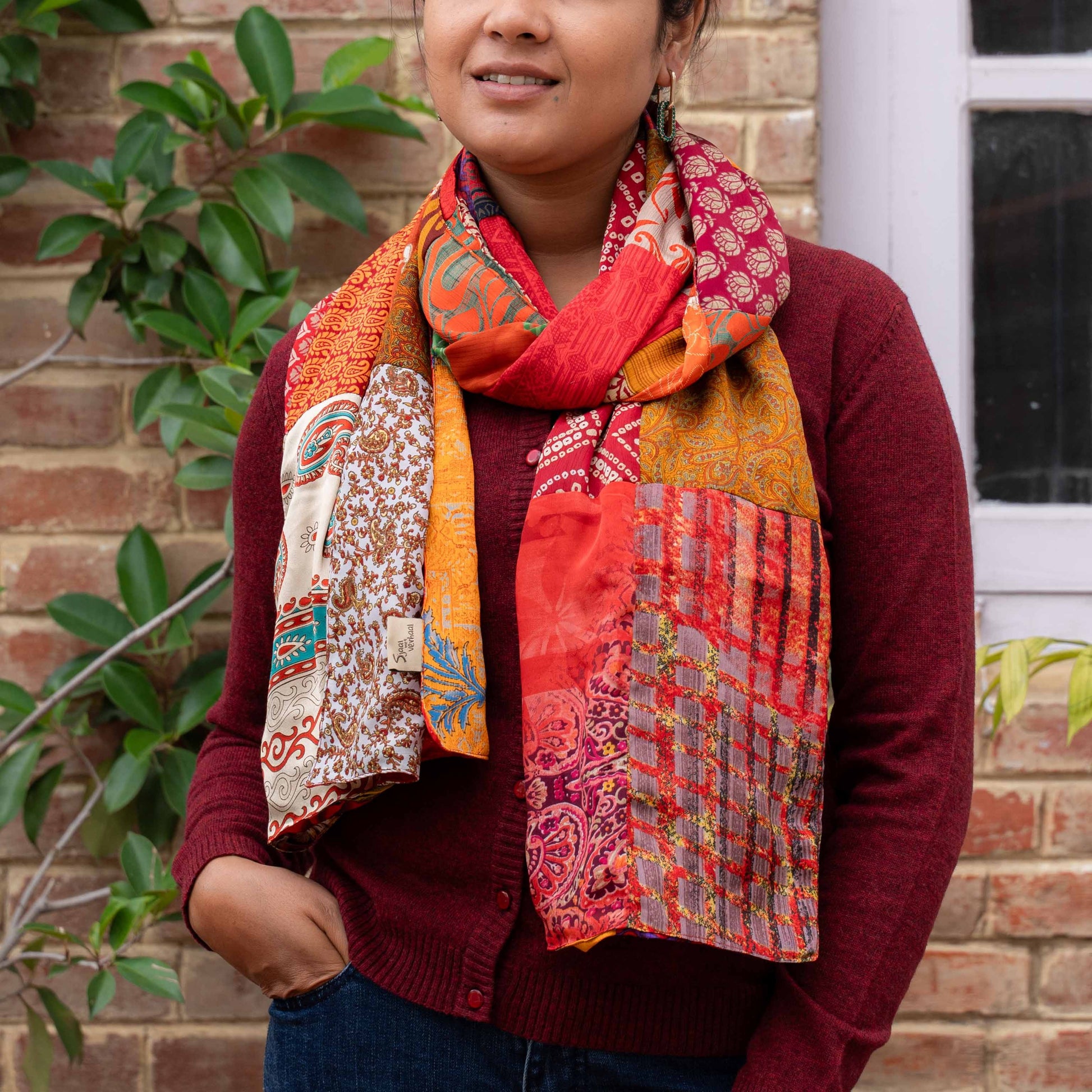 Detailfoto van vilten sarisjaal patchwork rood-oranjetinten
